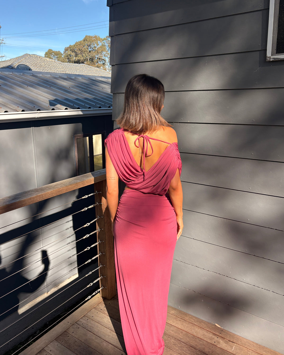 The Benni Celia Set in Rose Wine is a designer two-piece outfit featuring a gathered crop top with a versatile off-the-shoulder neckline and a matching draped maxi skirt. Crafted from soft stretch jersey in a rich rose wine hue, this elegant set is perfect for weddings, engagement parties, formal events, cocktail occasions, and special celebrations.