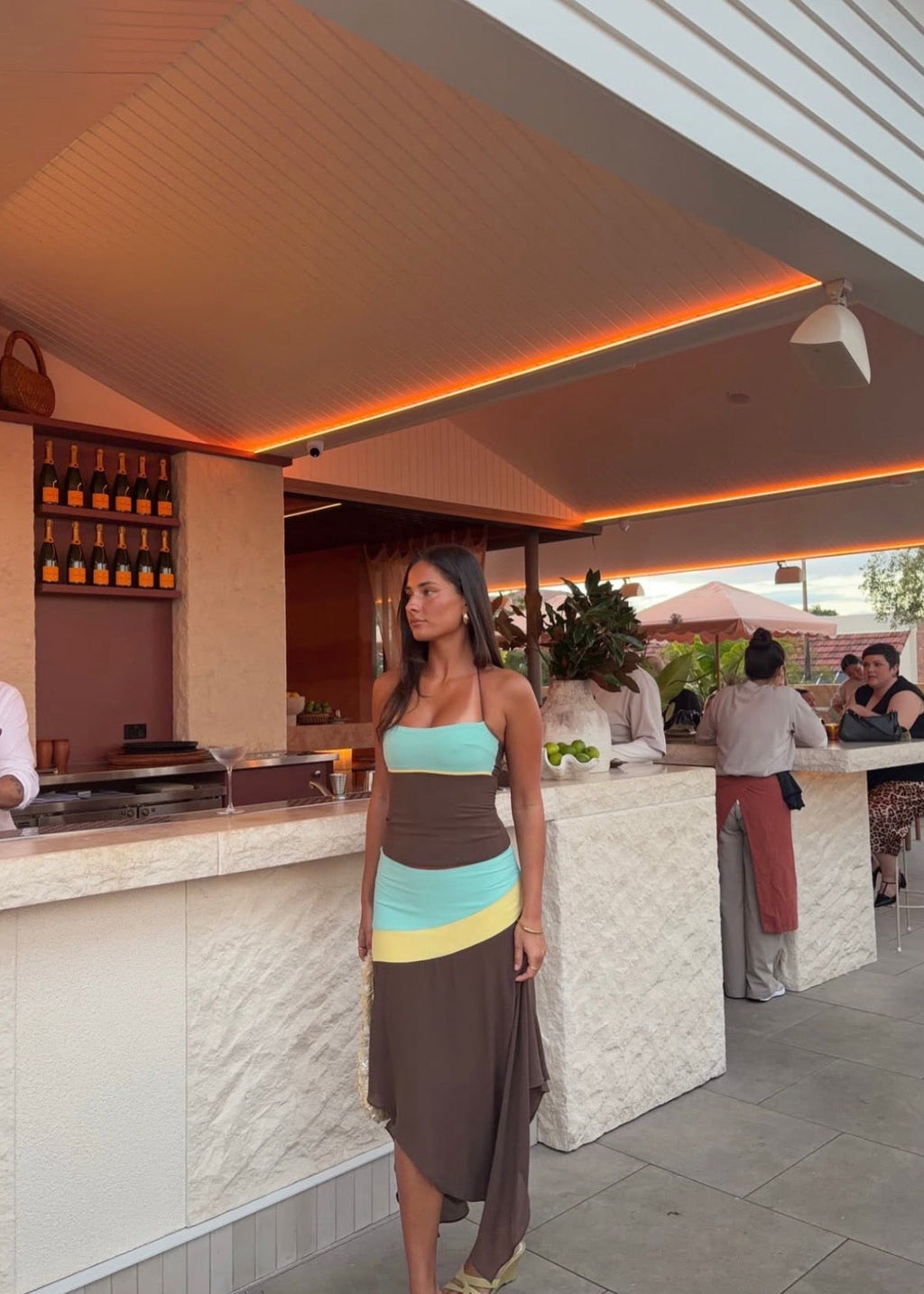 Sleeveless colour-block maxi dress featuring a turquoise bandeau bodice, chocolate brown fitted waist, pale yellow accent panels and an asymmetric flowing skirt. Designed with thin halter straps and a soft draped silhouette, perfect for weddings, races, holiday events and summer occasions.