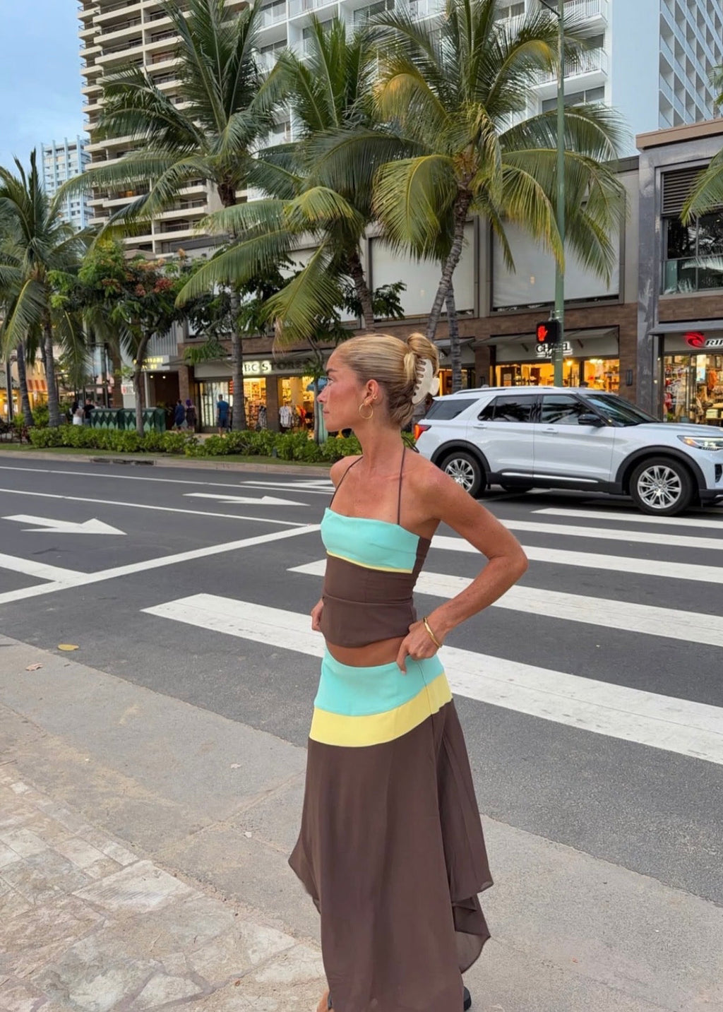 Sleeveless colour-block maxi dress featuring a turquoise bandeau bodice, chocolate brown fitted waist, pale yellow accent panels and an asymmetric flowing skirt. Designed with thin halter straps and a soft draped silhouette, perfect for weddings, races, holiday events and summer occasions.